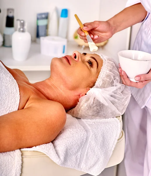 Woman middle-aged take face massage in spa salon. — Stock Photo, Image