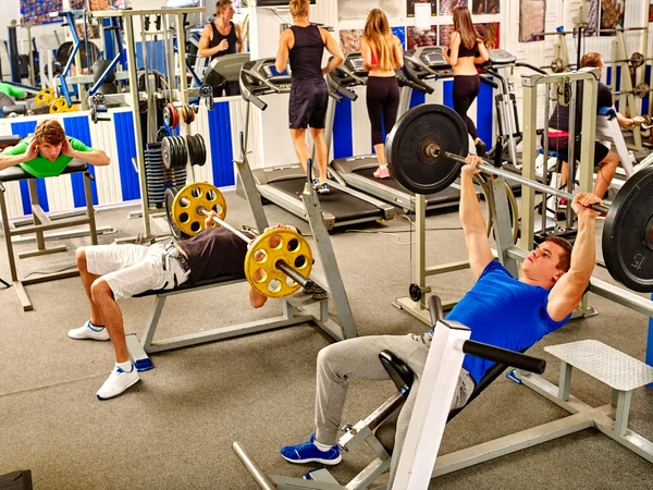 Gruppe von Menschen, die seinen Körper im Fitnessstudio bearbeiten. — Stockfoto