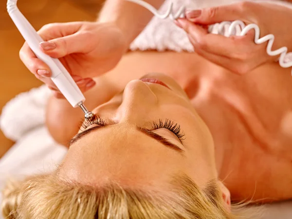 Mujer joven recibiendo masaje facial eléctrico . —  Fotos de Stock