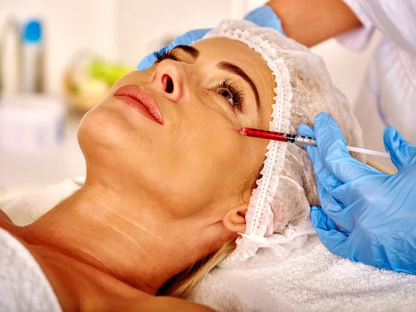 Mulher de meia-idade no salão de spa com esteticista. Mulher a administrar injecções de botox . — Fotografia de Stock