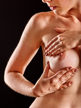 Kendi kendine muayene göğüs. Çıplak kız çıplak göğüsleri inceliyor.