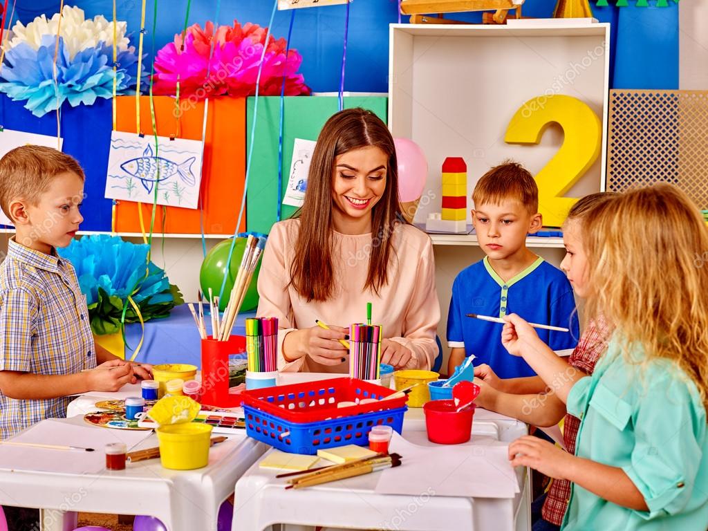 Kids with teacher woman painting on paper in kindergarten . — Stock ...