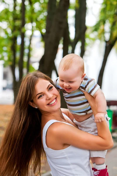 Feliz madre cariñosa y su bebé al aire libre . — Foto de Stock