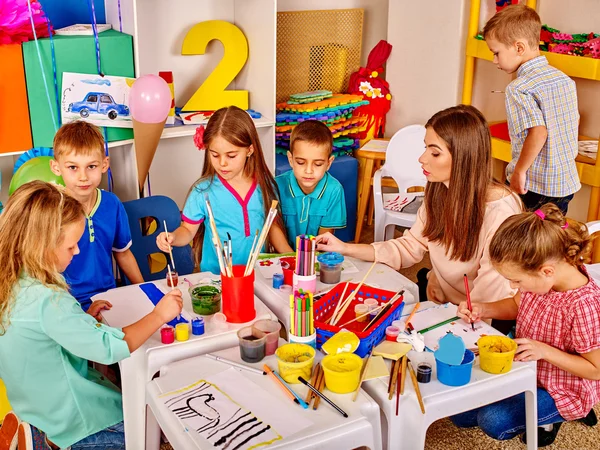 Niños con maestra pintando en el jardín de infantes  . — Foto de Stock