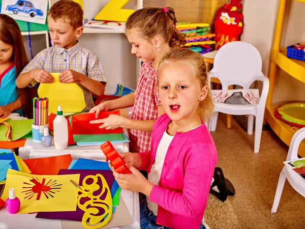 Niños sosteniendo papel de color en la mesa en el jardín de infantes  . —  Fotos de Stock