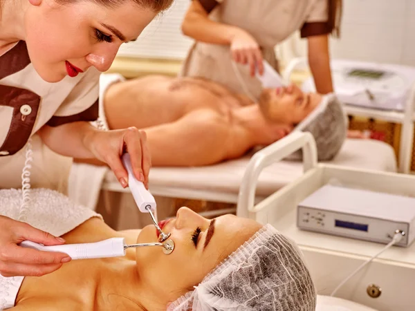 Jovem mulher recebendo massagem facial elétrica . — Fotografia de Stock