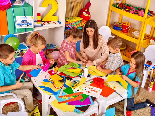 Children with teacher woman painting on paper in  kindergarten . — Stock Photo, Image