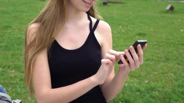 Close-up vrouw handen met behulp van touchscreen telefoon buitenshuis in stadspark — Stockvideo