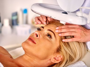 Spa salonda orta yaşlı kadın. Güzellik uzmanı tarafından tweezing kaş.