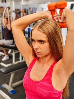 Halter sporu salona tutan kırmızı spor kız. Pazı ön plan.