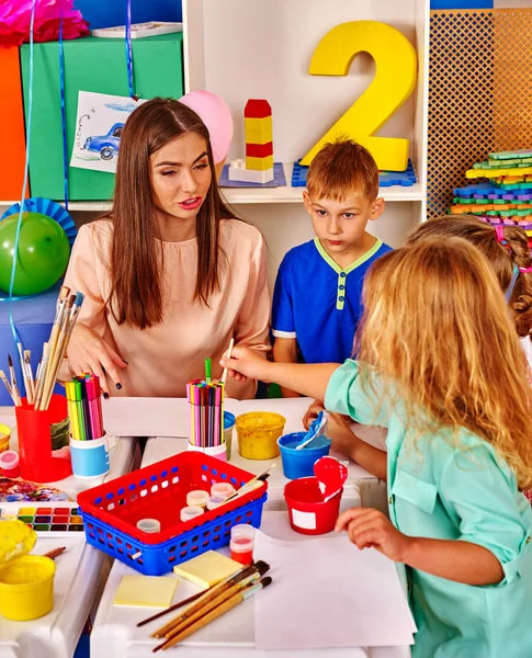 Children with teacher woman painting on paper in  kindergarten . — Stock Photo, Image