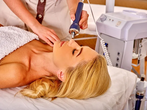 Mujer joven recibiendo masaje facial eléctrico . — Foto de Stock