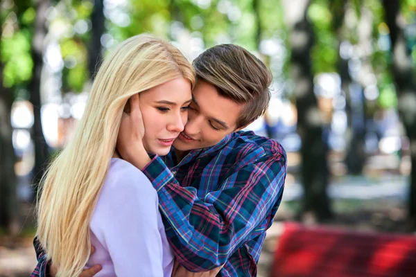 Jong koppel knuffelen en flirten in park. — Stockfoto