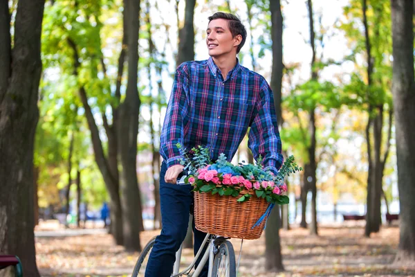 Piękny, młody człowiek na rowerze w parku — Zdjęcie stockowe
