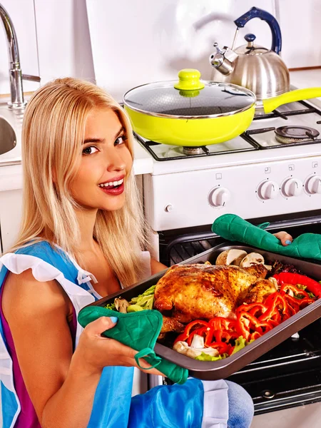 Mujer cocinando pollo en la cocina . — Foto de Stock