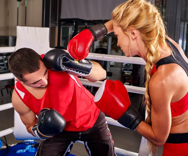 Boxerin mit männlichem Trainer beim Training. Mädchen schießt Mann ins Ohr. — Stockfoto