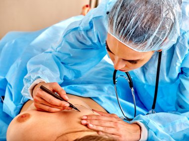 Doktor kadın meme üzerinde satır yapar 