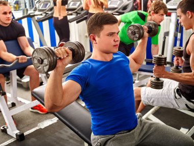 Grup insanlar ve mavi tişört dumbbells ile adam.