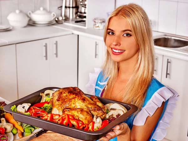 Mujer cocinando pollo con verduras en la cocina . — Foto de Stock