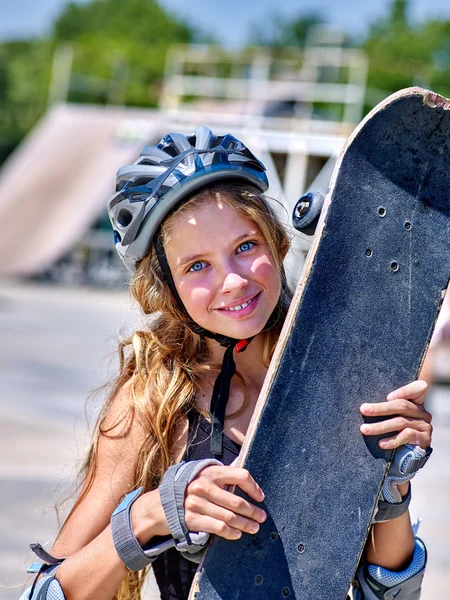 Chica sosteniendo un monopatín en las manos . — Foto de Stock