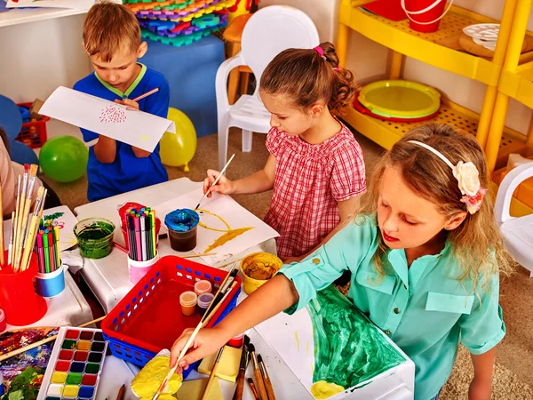 Gruppo di bambini disegna disegni nella piccola scuola materna . — Foto Stock