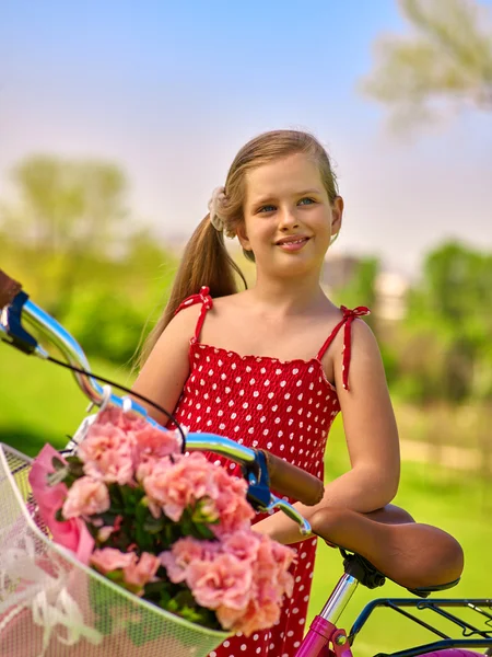 Menina vestindo bolinhas vermelhas passeios vestido bicicleta no parque . — Fotografia de Stock