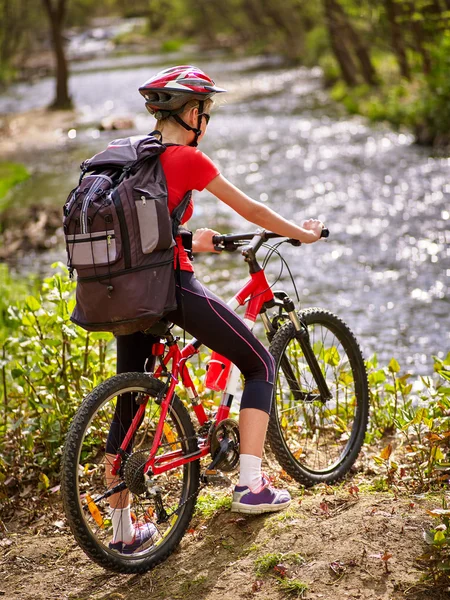 Bicicletas ciclismo chica con gran mochila ciclismo vadeando a través del agua  . — Foto de Stock