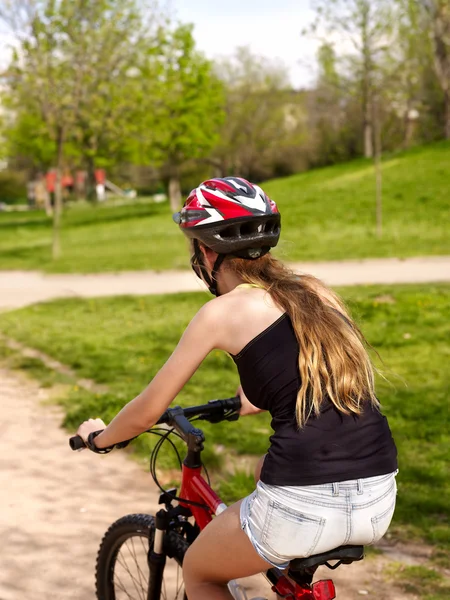 Ποδήλατα ποδήλατο κορίτσι φορώντας κράνος βόλτα στο δρόμο στο πάρκο. — Φωτογραφία Αρχείου