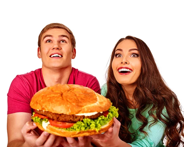 Uomo e donna che mangiano un grosso panino fastfood. Isolato . — Foto Stock