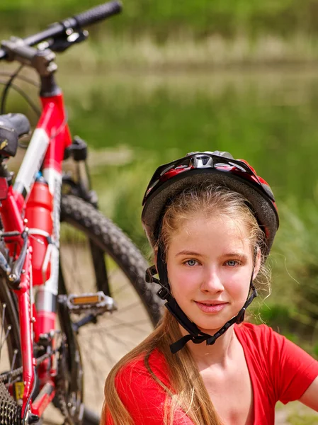 Bikes cycling girl wearing helmet have a rest sitting under tree. — Stock Photo, Image