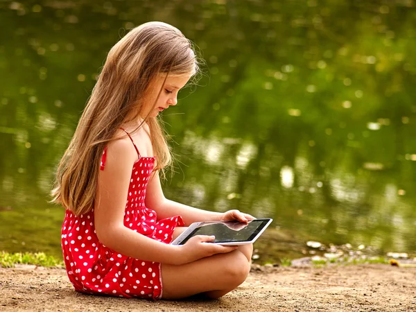 Cyklar cykling flicka i parken. Barnen titta på TabletPC. — Stockfoto