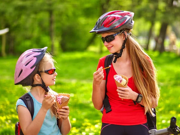 Cyklar cykling flickor med ryggsäck cykling äter glasstrut i sommaren park. — Stockfoto