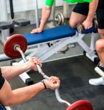 Kollarını ve göğüs spor salonunda çalışan adam.