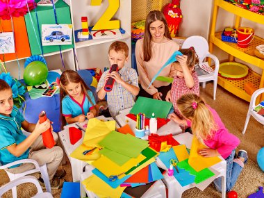 Evlat holding kağıt anaokulu tablo üzerinde renkli .