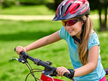 Kız rides Bisiklet Park açık yeşil çimenlerin üzerinde Bisiklete binme Bisiklet.