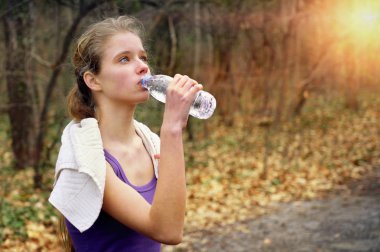 Kadın atlet parkında park yolundaki koşu.