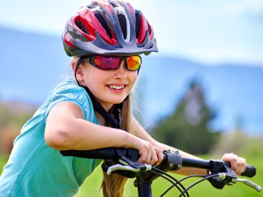 Kız rides Bisiklet Park açık yeşil çimenlerin üzerinde Bisiklete binme Bisiklet.