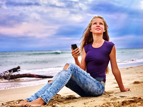 Девушка на песке рядом с морем вызов помощи по телефону . — стоковое фото