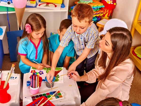 Niños con maestra pintando sobre papel en el jardín de infantes  . —  Fotos de Stock