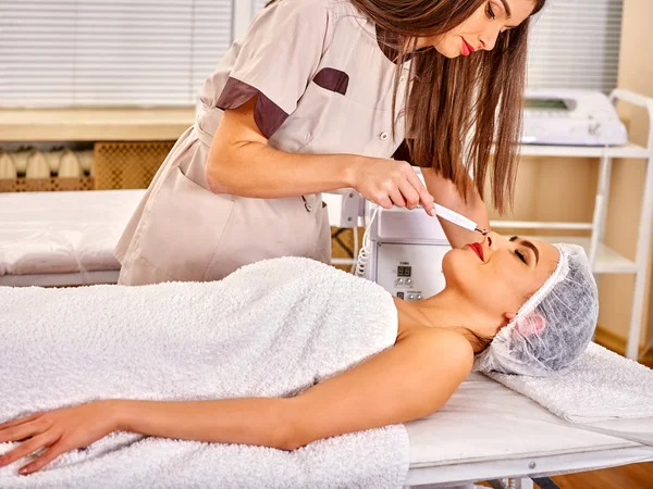 Jovem mulher recebendo massagem facial elétrica . — Fotografia de Stock