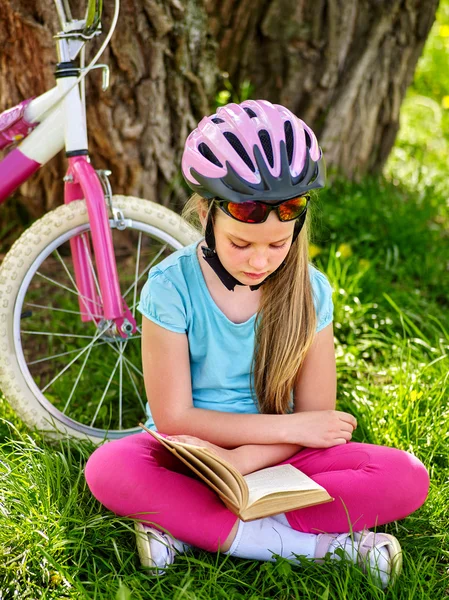 Fahrrad fahrendes Mädchen mit Helm las Buch auf Rastplatz neben Fahrrad. . — Stockfoto