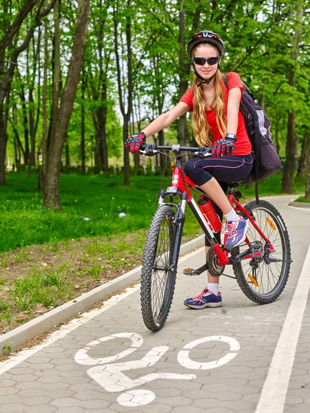 Mädchen trägt Fahrradhelm und Rucksack auf Rennrad. — Stockfoto