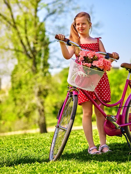 Niña vistiendo lunares blancos vestido monta bicicleta  . — Foto de Stock