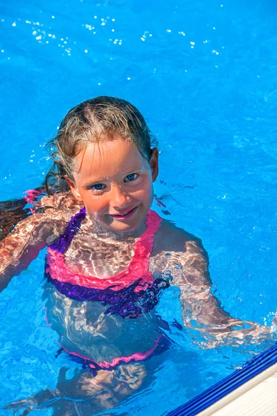 Dziecko pływać w niebieska woda w basenie. — Zdjęcie stockowe