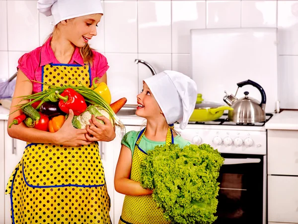 Barn liten flicka matlagning grönsaker på kök. — Stockfoto