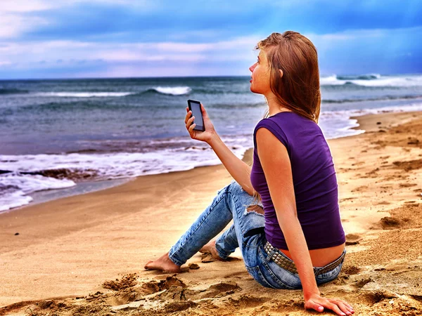 Fille sur le sable près de la mer appeler l'aide par téléphone . — Photo