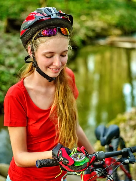 Fahrradfahrerinnen mit Helm schauen auf Kompass. — Stockfoto