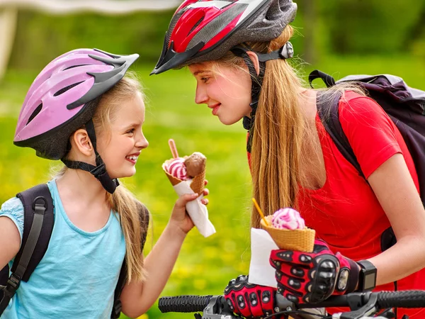 Rowerów dziewczyny jedzenie lodów stożek w parku. — Zdjęcie stockowe