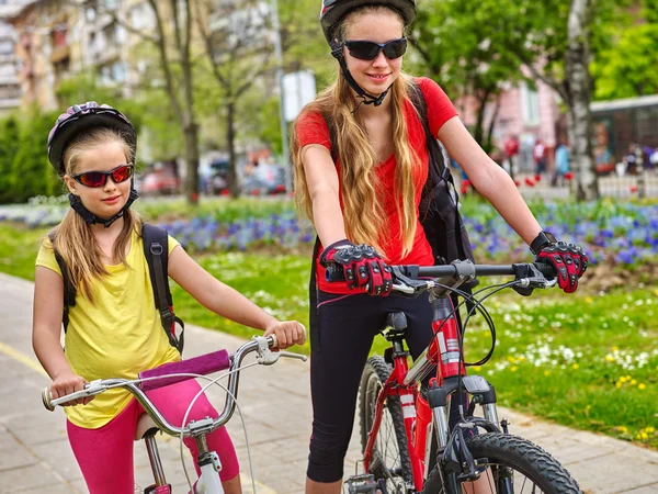 Bicicletas ciclismo niñas con mochila en carril bici . — Foto de Stock