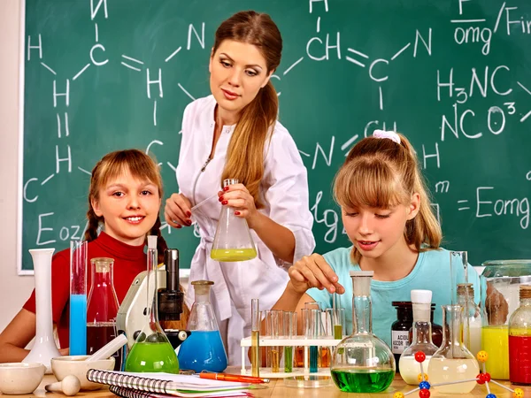 Crianças menina e professor segurando frasco na aula de química . — Fotografia de Stock